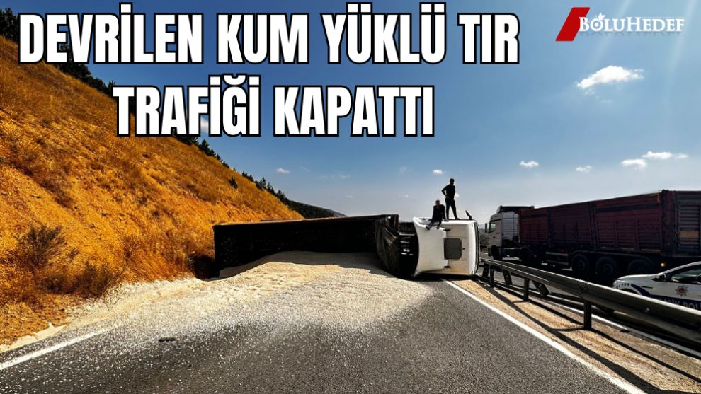 DEVRİLEN KUM YÜKLÜ TIR KARAYOLUNU KAPATTI